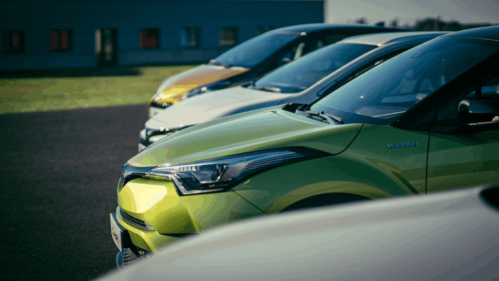 Gas hybrid and electric vehicles lined up showing ownership cost differences.