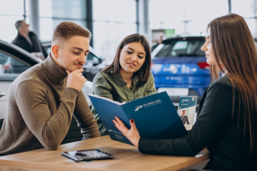 Car buyers reviewing paperwork, highlighting hidden car buying fees and contract.