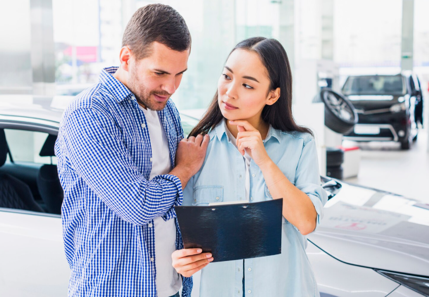 Car buyers reviewing vehicle pricing and ownership costs during inflation-driven car shopping.